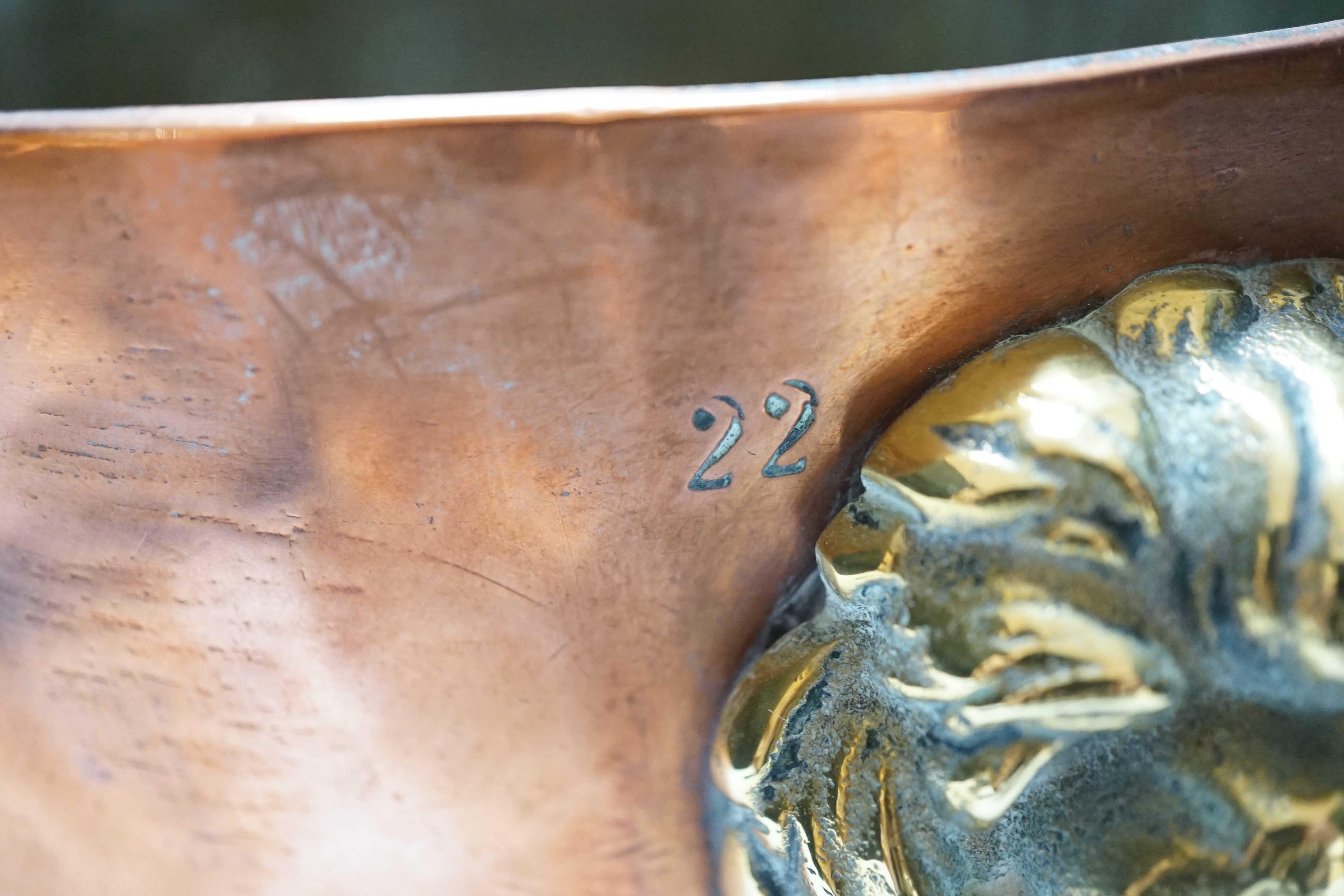 A heavy copper planter or cooking pot, with cast brass lion mask and ring handles, on brass claw feet, 20cm high